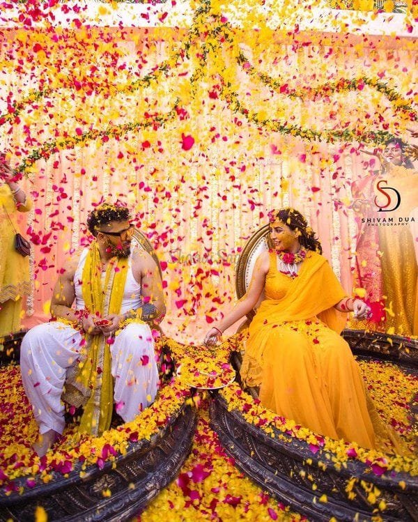Outdoor Haldi decor with yellow drapes and rustic photography setup